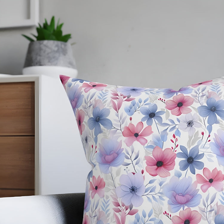 A corner of a cushion showcasing one of our custom designs, a delicate floral pattern in light blue and pink.